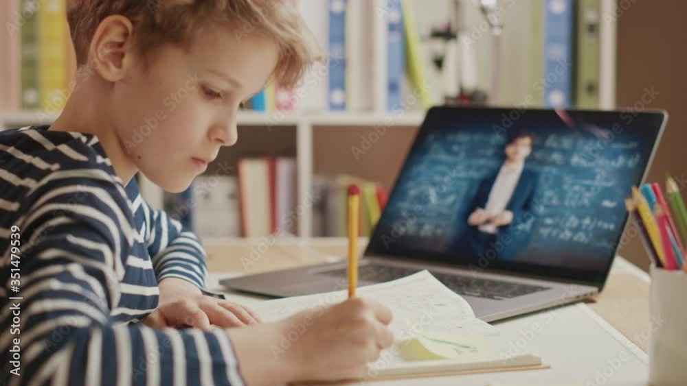 Smart Little Boy Uses Laptop for Video Call with His Teacher. Screen Shows Online Lecture with Teacher Explaining Subject from a Classroom. E-Education Distance Learning, Homeschooling Smart Little Boy Uses Laptop for Video Call with His Teacher. Screen Shows Online Lecture with Teacher Explaining Subject from a Classroom. E-Education Distance Learning, Homeschooling
