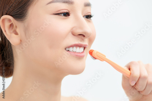Studio portrait of a beautiful young woman holding a toothbrush with toothpaste on it