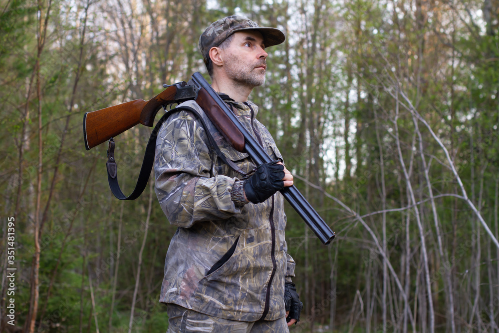 Fototapeta premium the hunter holds an unloaded rifle on his shoulder