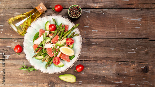 Asparagus salad grapefruit, cherry tomatoes, avocado, chicken fillet, spinach in bowl. top view. Long banner format. space for text.