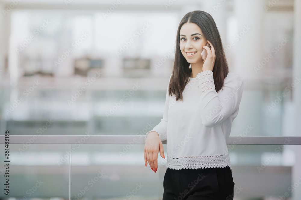 Smiling female student making a call before an exam at university Smiling female student making a call before an exam at university