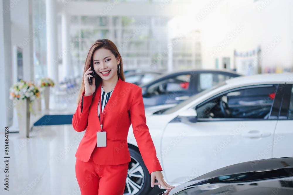 Car salesmen, beautiful women, Asian women who are talking on the phone with customers to sell new cars in car showrooms, automotive businesses, car sales, management, gestures and people. Car salesmen, beautiful women, Asian women who are talking on the phone with customers to sell new cars in car showrooms, automotive businesses, car sales, management, gestures and people.