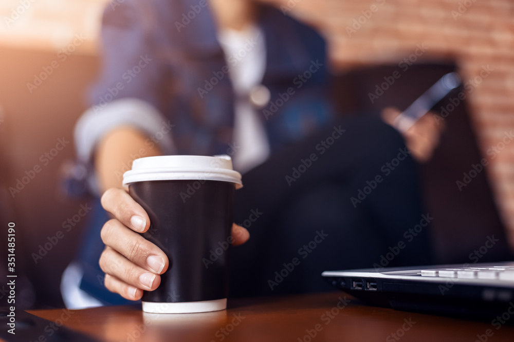 happy woman's hands holding mobile phone and coffee cup in cafe and she sitting on sofa. happy woman's hands holding mobile phone and coffee cup in cafe and she sitting on sofa.