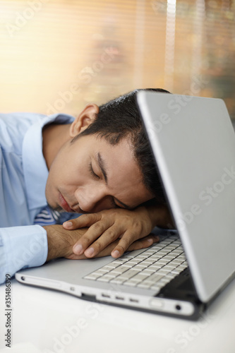 Young businessman sleeping on laptop