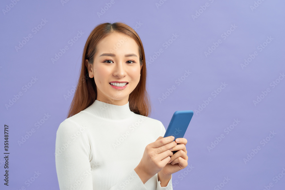 Portrait of a happy young girl holding mobile phone isolated Portrait of a happy young girl holding mobile phone isolated