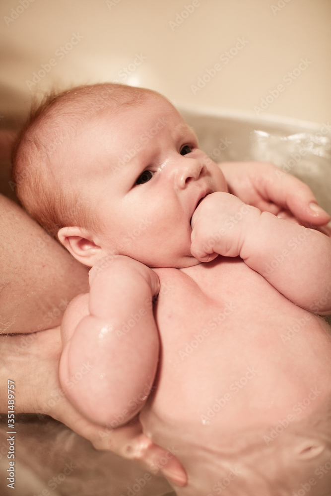 Newborn baby girl being held in the bath Newborn baby girl being held in the bath