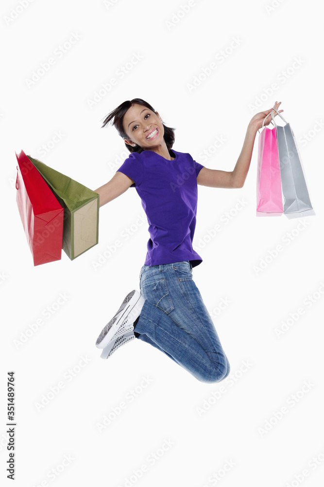 Woman with shopping bags jumping in the air Woman with shopping bags jumping in the air