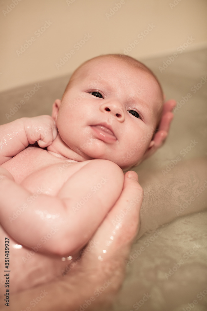 Newborn baby girl being held in the bath Newborn baby girl being held in the bath
