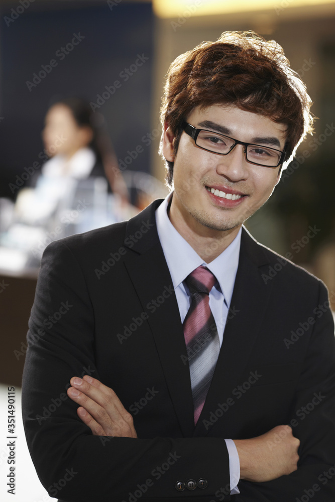 Fototapeta premium Businessman smiling with arms crossed