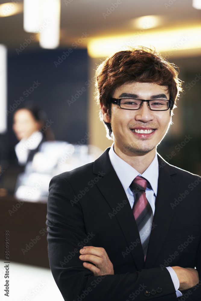 Fototapeta premium Businessman smiling with arms crossed
