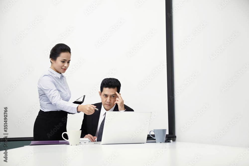 Businessman and businesswoman having discussion in meeting room