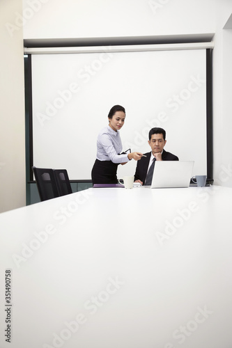 Businessman and businesswoman having discussion in meeting room