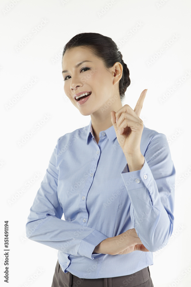 Mid adult businesswoman holding up her index finger Mid adult businesswoman holding up her index finger