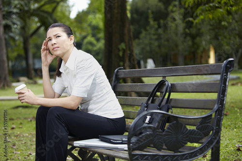 Mid adult businesswoman having a coffee break in park © ImageHit