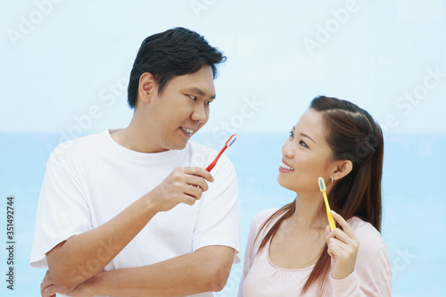 Man and woman holding toothbrush
