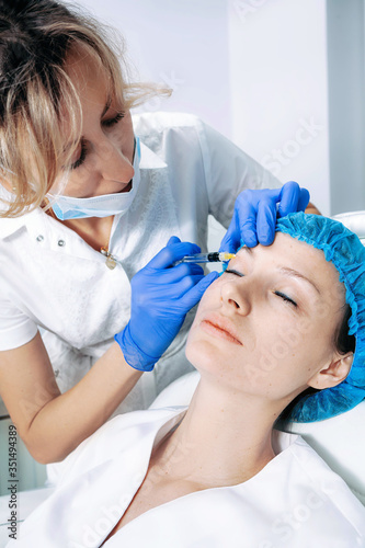 doctor cosmetologist makes Rejuvenating Biorevitalization facial injections procedure on female skin in beauty salon