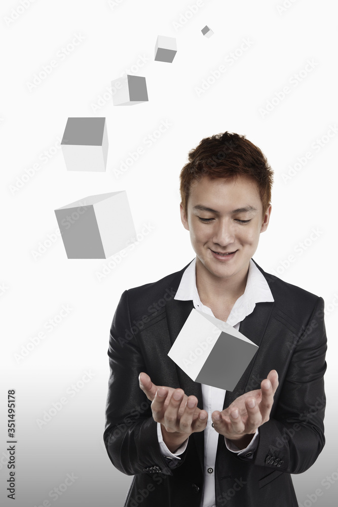 Businessman holding a set of cubes in different sizes Businessman holding a set of cubes in different sizes