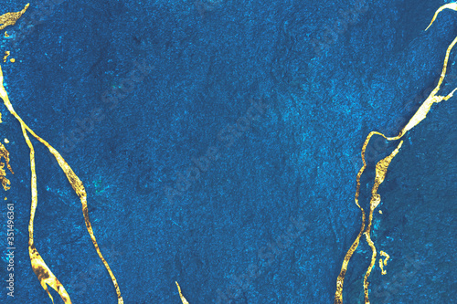 Gold marbling on blue bacground photo