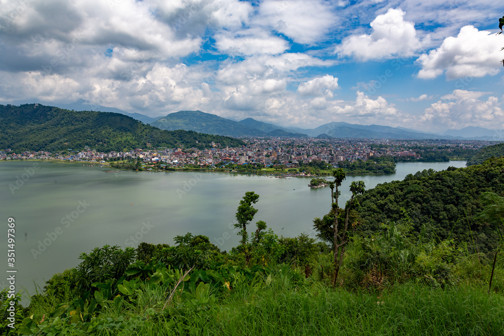View of Pokhara city and lake from above with green forest and white clouds