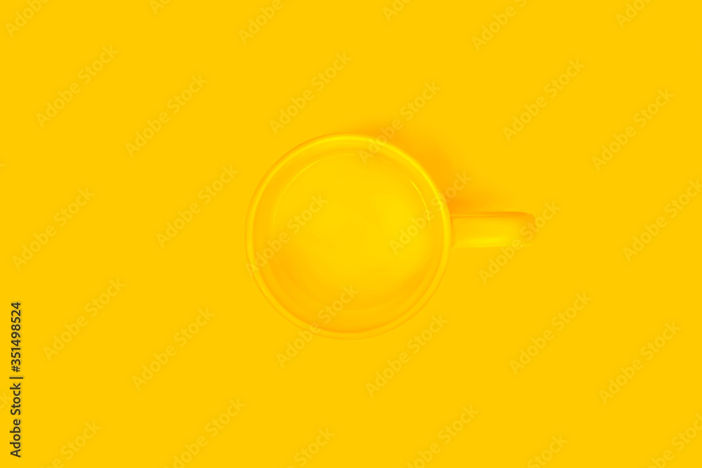 Fototapeta Yellow cup on a yellow background.