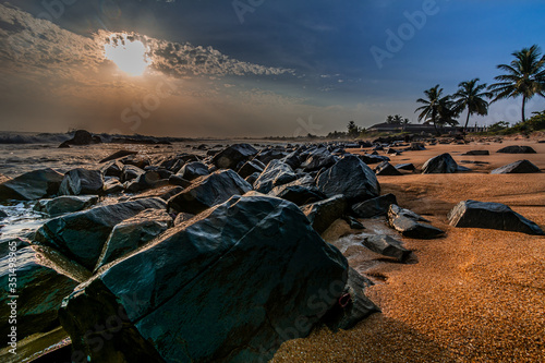 Beach with red sand and black rocks with a beautiful sunset in Congo Town, Monrovia, Liberia photo