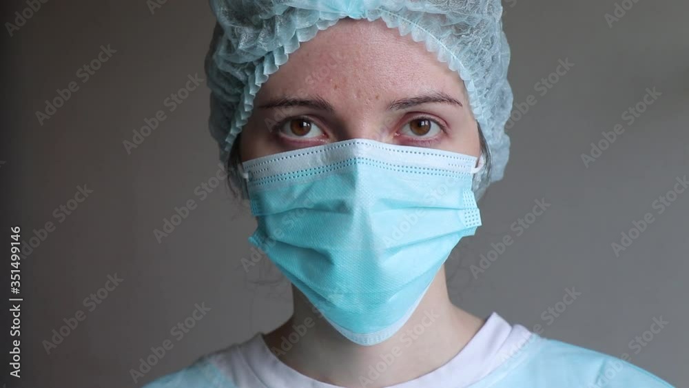 doctor in medical rubber gloves corrects a medical mask on his face doctor in medical rubber gloves corrects a medical mask on his face