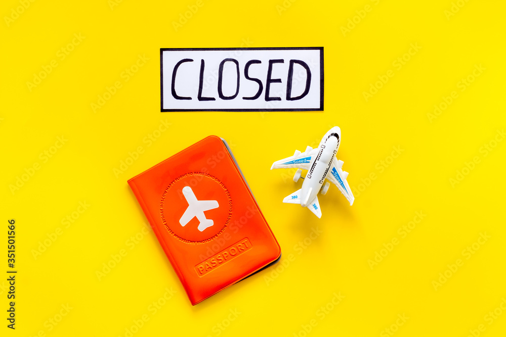 Closed counrty borders - coronovirus quarantine. Airplane and passport on yellow background top view copy space