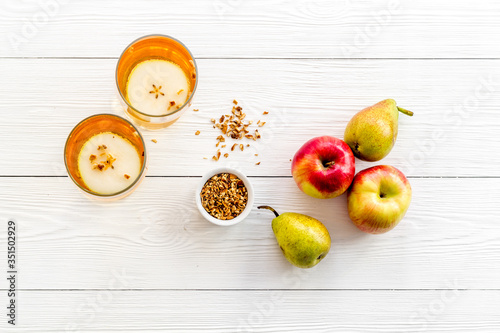 Fruit drinks with apple and pear on white wooden background from above photo