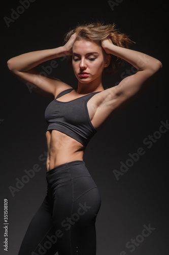 Young girl doing yoga on a black background