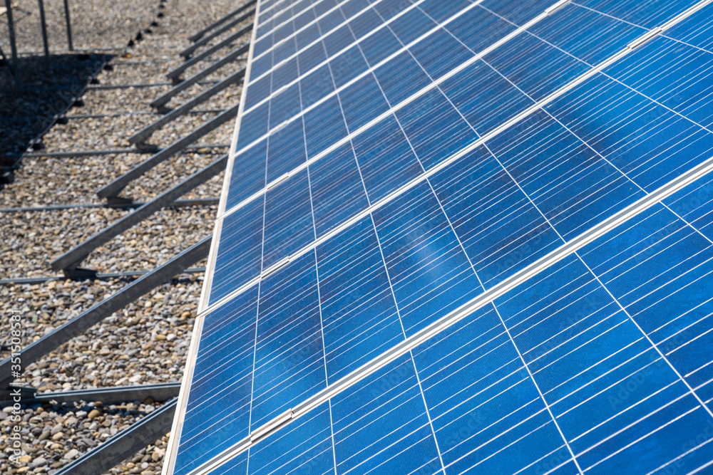 Obraz premium close up view of a row of modern solar panels on a flat rooftop
