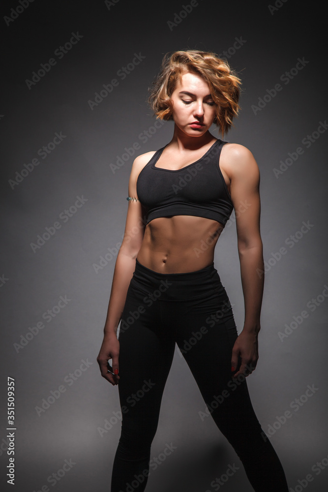 Young girl doing yoga on a black background