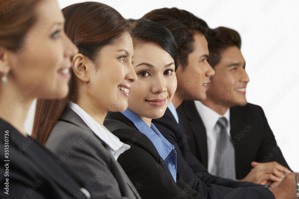 Side view shot of business people sitting together Side view shot of business people sitting together