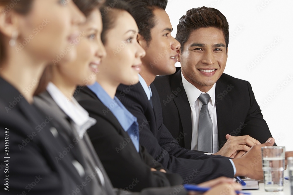 Side view shot of business people sitting together Side view shot of business people sitting together