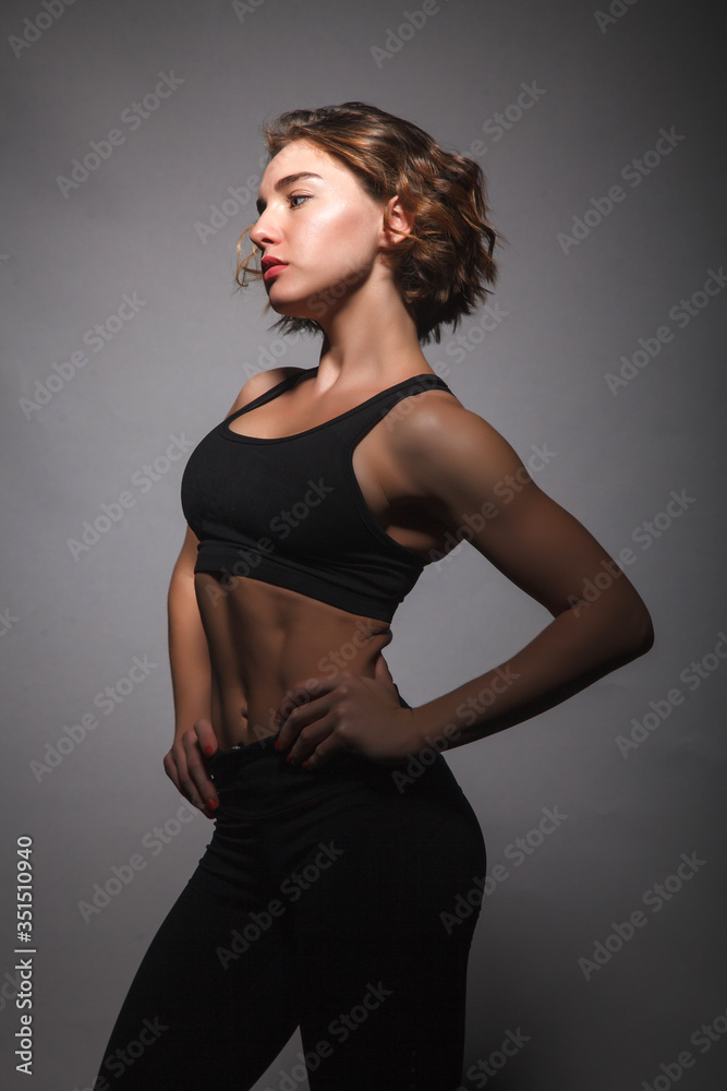 Fototapeta premium Young girl doing yoga on a black background