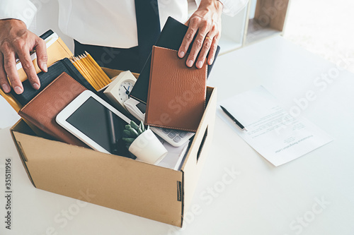 Sad dismissed businessman sitting outside the office after losing his job photo