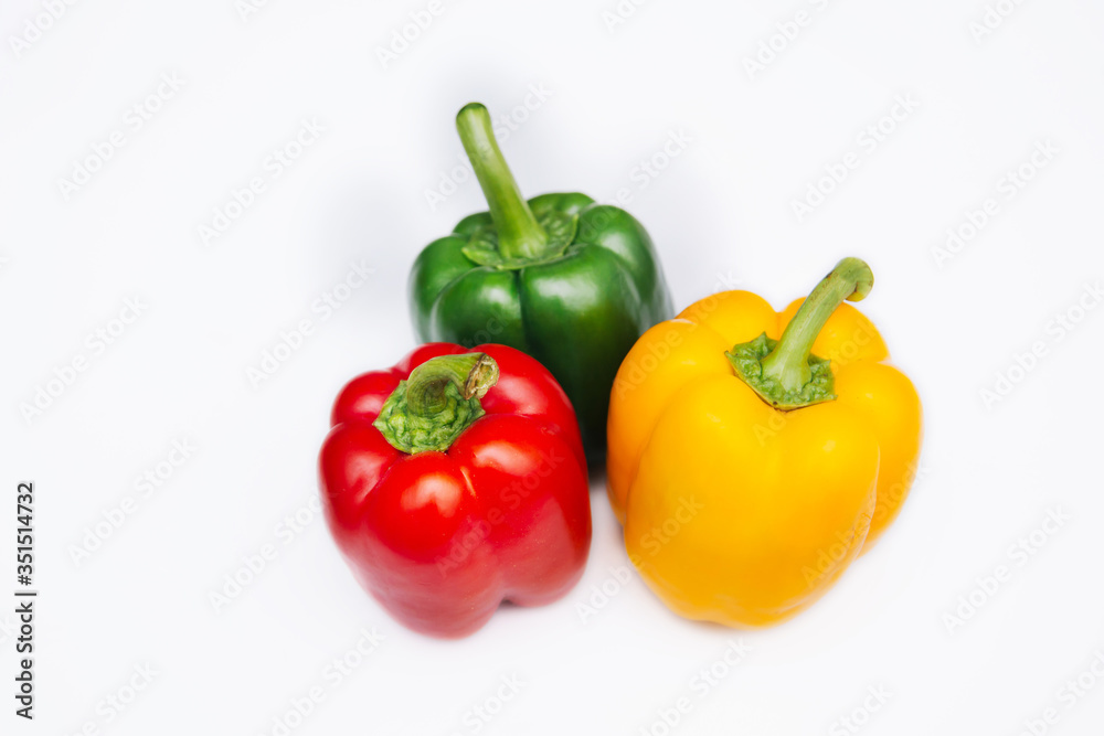 Sweet pepper multicolored on a white background. Red, yellow and green peppers lie on a light table. Bright vegetable isolate Sweet pepper multicolored on a white background. Red, yellow and green peppers lie on a light table. Bright vegetable isolate