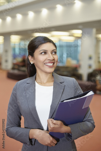 Cheerful businesswoman holding files