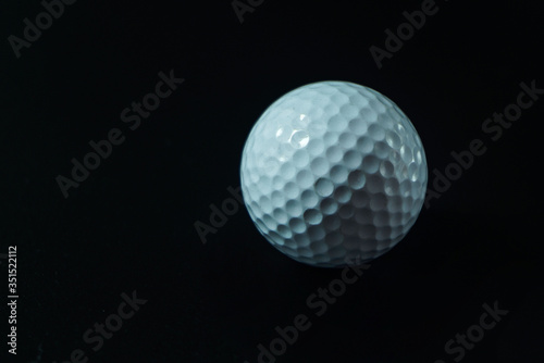 White golf ball on black background with copy space