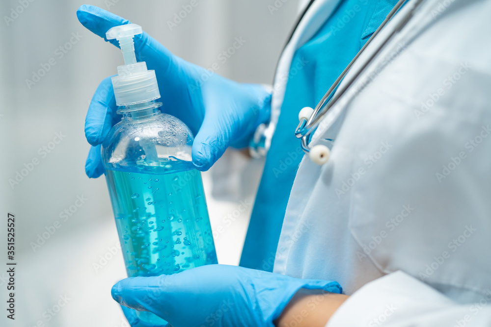 Doctor holding blue alcohol sanitizer gel for patient to protect safety infection and kill Novel Coronavirus Covid-19 virus, bacteria and germs. Doctor holding blue alcohol sanitizer gel for patient to protect safety infection and kill Novel Coronavirus Covid-19 virus, bacteria and germs.