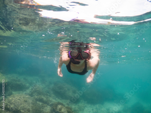Underwater portrait of a woman snorkeling in tropical sea.