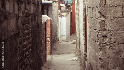An alleyway with white brick wall in between