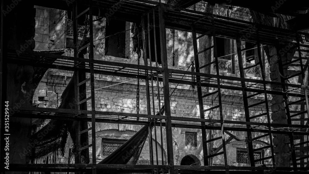 Black and white photo of a brick building with ladder Black and white photo of a brick building with ladder