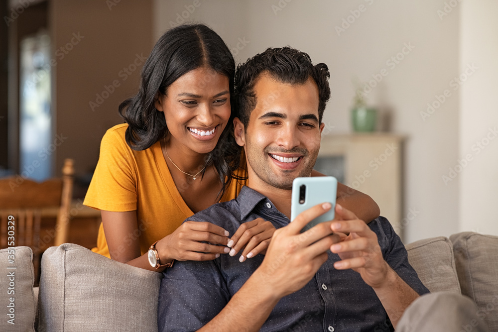 Indian couple using smartphone at home Indian couple using smartphone at home