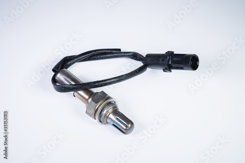 The oxygen sensor is a new lambda sensor. Spare parts on the car on a gray gradient background