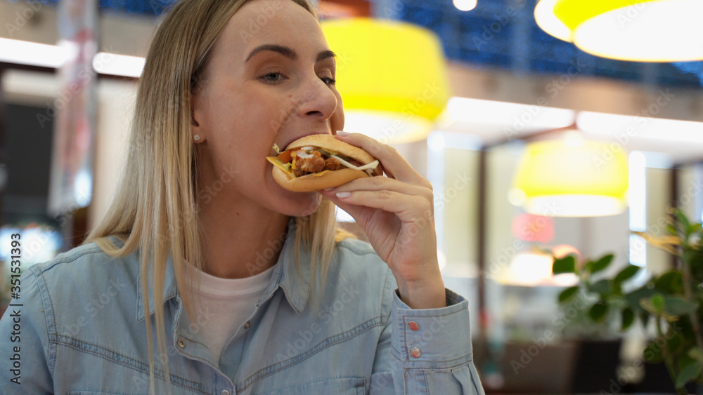 Smiling Woman Blonde Eating Meals Burger in Mall Fast Food Cafe