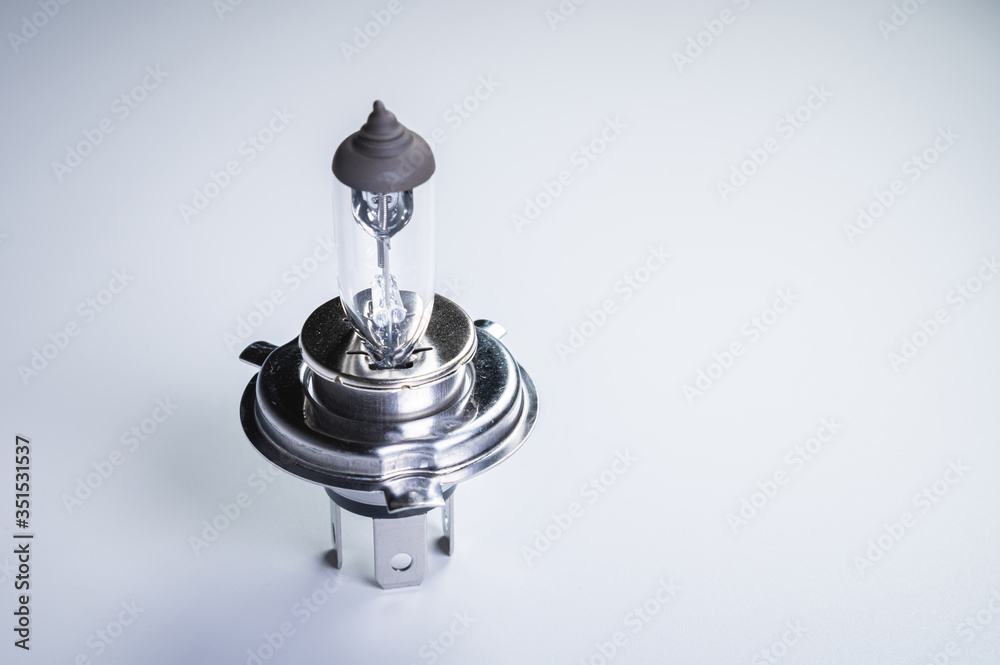 One new halogen light with an H4 cinder on a grey gradient background. New car parts for external car lighting systems One new halogen light with an H4 cinder on a grey gradient background. New car parts for external car lighting systems