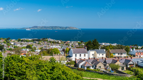 Dalkey village houses as seen from the hill top with the Howth peninsula on the horizon. Sunny summer day in Dublin, Ireland.