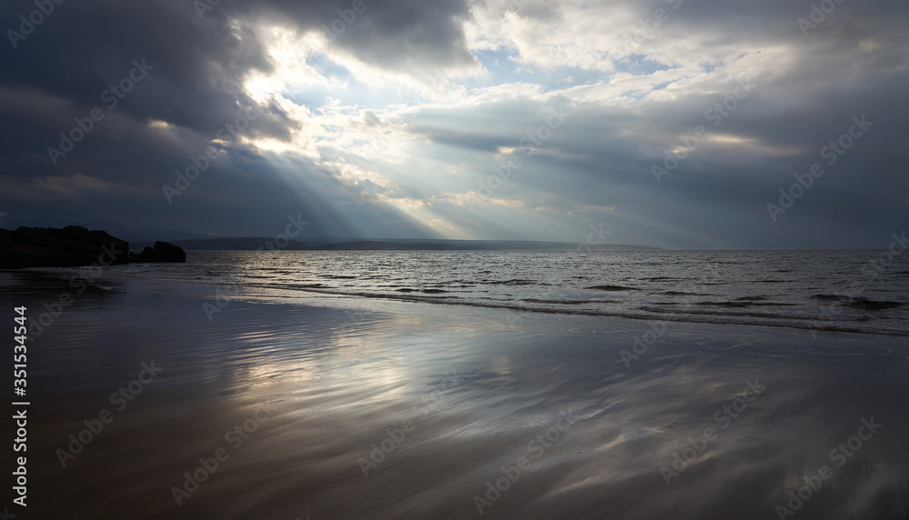 Rays of autumn sunlight breaking through the cloud aover the wet beach of Big Sand near Gairloch in the Scottish Highlands, Scotland, UK. Rays of autumn sunlight breaking through the cloud aover the wet beach of Big Sand near Gairloch in the Scottish Highlands, Scotland, UK.
