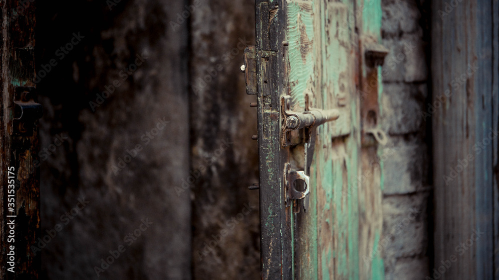 Green wooden door with lock mounted on