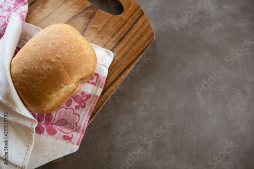 Wheat homemade bread on a wooden desk. Grey background. Horizontal.